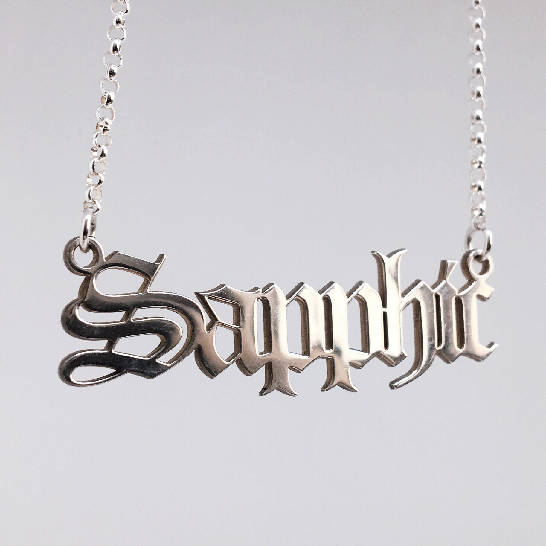 Sterling silver Sapphic nameplate necklace in gothic blackletter font.