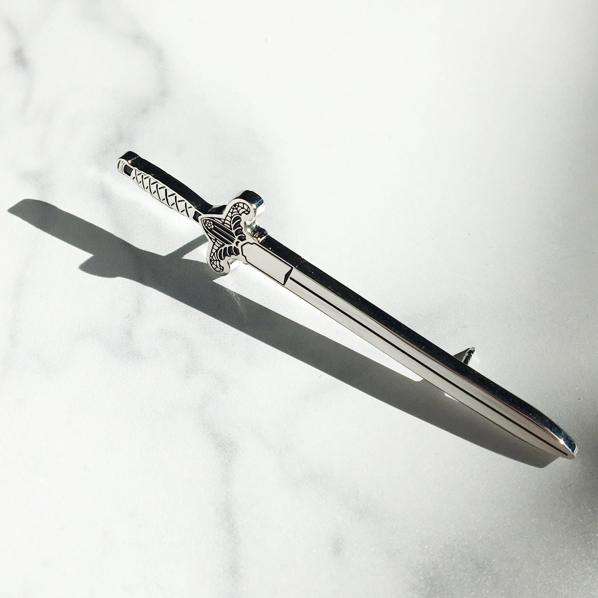 Gothic Sword enamel pin in silver and black enamel.