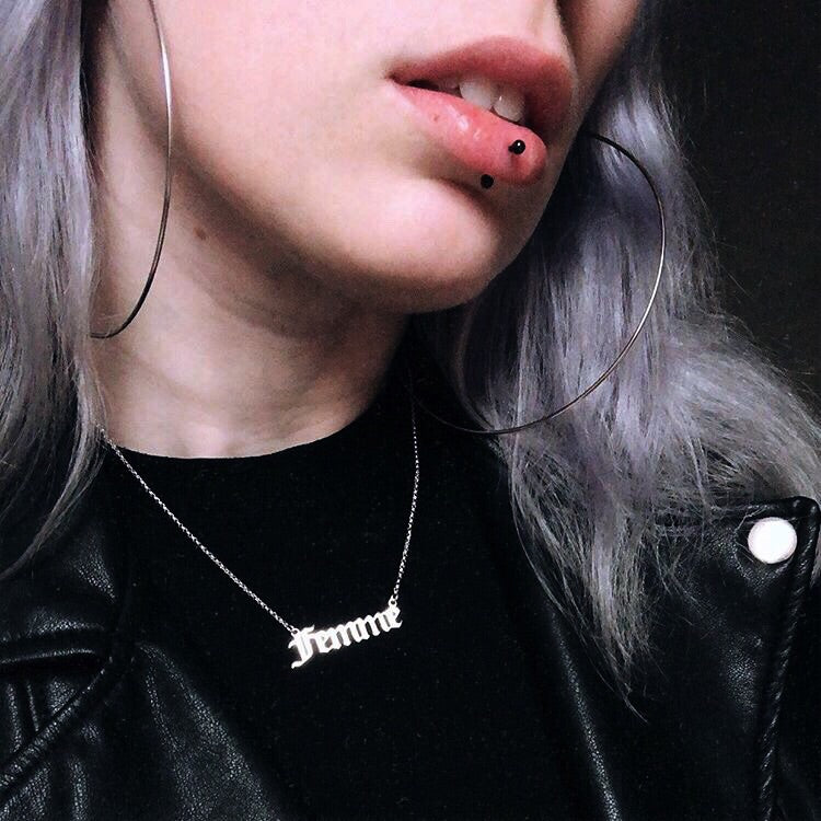 Gothic blackletter Femme Nameplate Necklace in sterling silver worn on a model with a black shirt